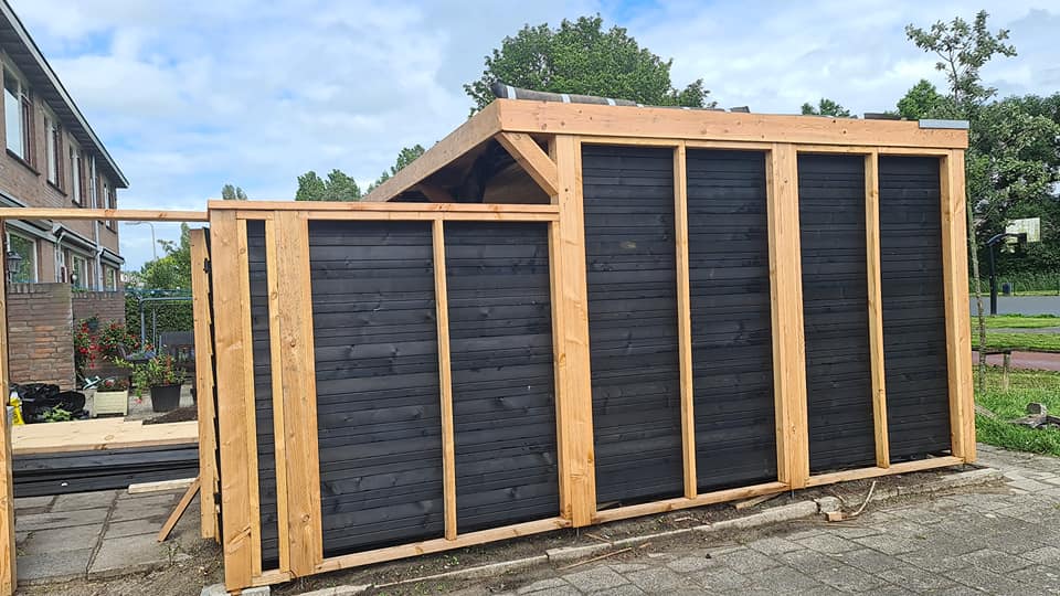 Nieuwe zwarte houten berging op een vuren frame