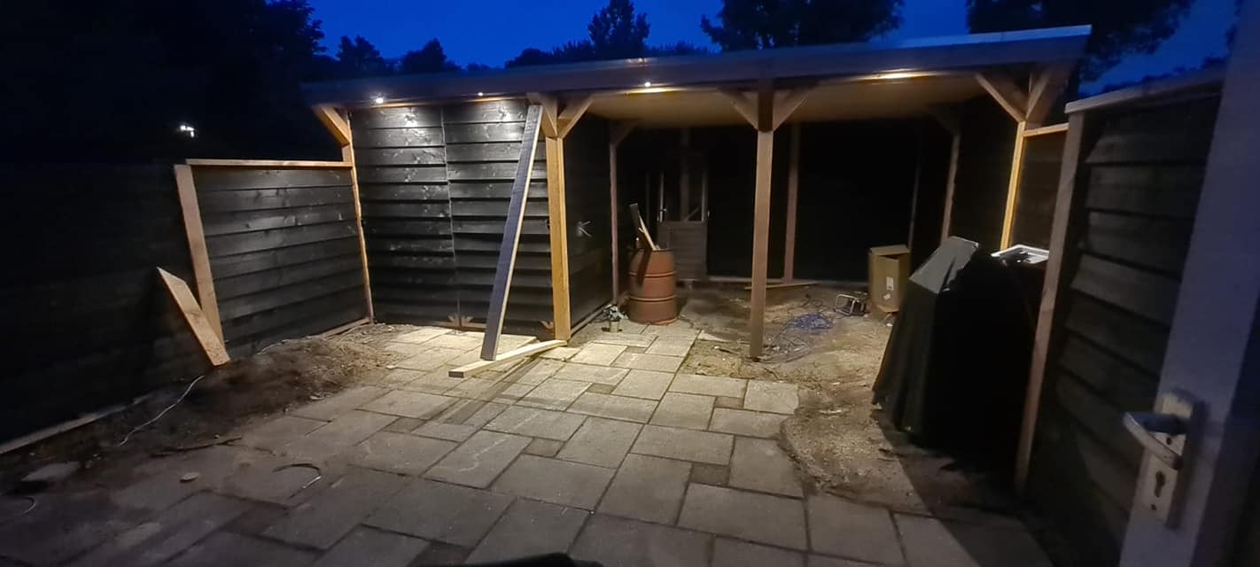 Afgewerkte overkapping met ingebouwde verlichting in de avond